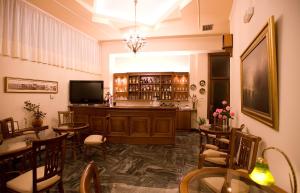 un restaurante con mesas y sillas y un bar en Hotel Urania, en Preveza
