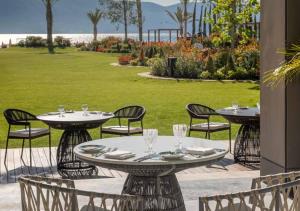 a patio with two tables and chairs and a lawn at One&Only Portonovi in Herceg-Novi