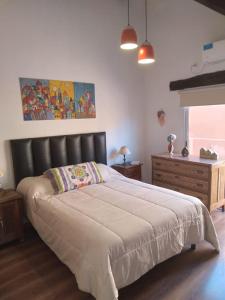 a bedroom with a large bed with a black headboard at Flor de Lis in Capilla del Monte