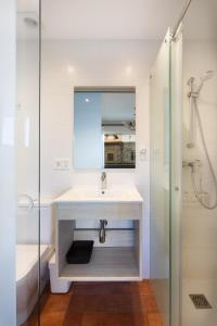 a white bathroom with a sink and a shower at Pensión Zarauz Playa in Zarautz