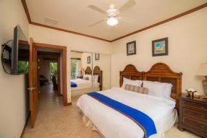 a bedroom with two beds and a flat screen tv at Los Suenos Resort Veranda 6C by Stay in CR in Herradura