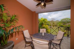 a dining room with a table and chairs and a balcony at Los Suenos Resort Veranda 6C by Stay in CR in Herradura