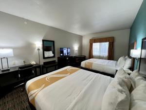 Quality Inn & Suites Near University في واكو: غرفه فندقيه سريرين وتلفزيون