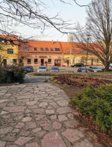 uma passagem de pedra em frente a um edifício em Váralja Vendégház em Tata