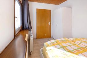 1 dormitorio con 1 cama y puerta de madera en Am Bächle, en Lenzkirch