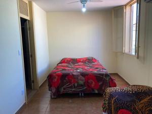 um quarto com uma cama com um cobertor vermelho em Solar dos Costais: casa com 4 suítes climatizadas em Uberaba