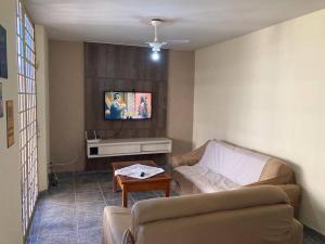 uma sala de estar com um sofá e uma mesa em Solar dos Costais: casa com 4 suítes climatizadas em Uberaba