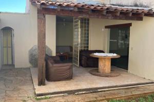 an outdoor patio with a table and a couch at Solar dos Costais: casa com 4 suítes climatizadas in Uberaba