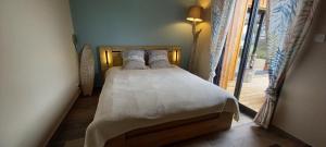 a bedroom with a bed with white sheets and pillows at Agréable villa neuve orientée vers la nature et le coucher de soleil! in Le Verdon-sur-Mer