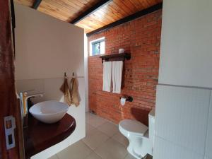 a bathroom with a sink and a brick wall at Palm Village in Nueva Italia