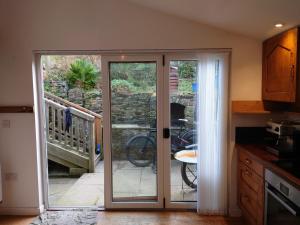a kitchen with a sliding glass door leading to a patio at Fern Cottage Annexe in Croyde