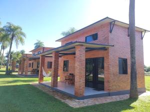 a brick house with a patio in a yard at Palm Village in Nueva Italia