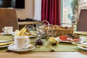 einen Tisch mit einem Teller mit Lebensmitteln und einem Korb mit Lebensmitteln in der Unterkunft Bayern Chalets in Ainring