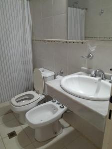 Baño blanco con aseo y lavamanos en Brisas del Lago Apartamentos en Colón