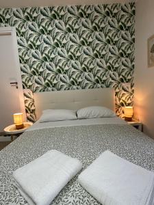 una camera da letto con un grande letto con un muro di foglie di Casa flowers 1 a Ciampino