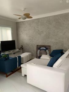 ein Wohnzimmer mit einem Sofa und einem TV in der Unterkunft Casa em Riviera de São Lourenço Prática e Confortável, Reformada e Equipada! in Bertioga