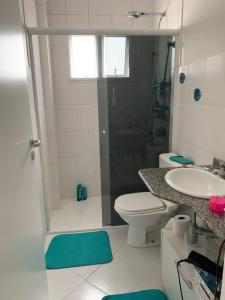 y baño con ducha, aseo y lavamanos. en Casa em Riviera de São Lourenço Prática e Confortável, Reformada e Equipada! en Bertioga