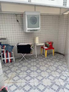 uma cozinha com uma televisão e uma mesa e cadeiras em Casa em Riviera de São Lourenço Prática e Confortável, Reformada e Equipada! em Bertioga