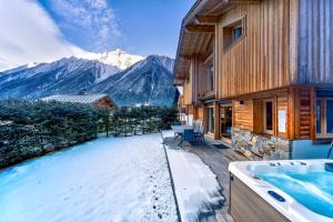 a house with a bath tub and a view of mountains at Chalet Planards 1 in Chamonix-Mont-Blanc