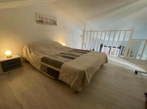 - une chambre avec un lit, une table de nuit et un escalier dans l'établissement San Lucianu - Appt vue mer et montagne, à LʼÎle-Rousse