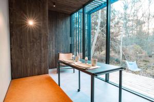 a dining room with a table and a large window at WoodHouse Denmark in Hadsund