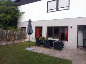 a patio with an umbrella and a table and chairs at Haus am Römerstich in Auen