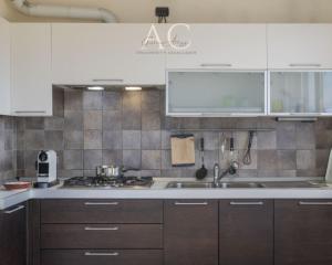 a kitchen with white cabinets and a sink at The House on the Lake in Reno Di Leggiuno