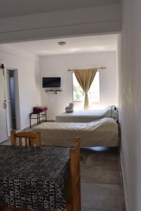 1 dormitorio con 2 camas y ventana en La Escala ll en Corrientes