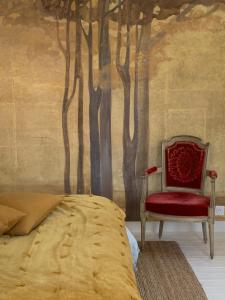 - une chambre avec un lit et une chaise rouge dans l'établissement Chambre Suite d'hôte à Ouville la Rivière Normandie, à Ouville-la-Rivière