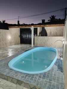 马拉戈日Casa Praia Maragogi - Peroba的夜晚在庭院里有一个蓝色的游泳池