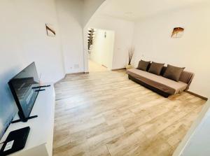 sala de estar con sofá y suelo de madera en La Calzada Apartment, en Tafira