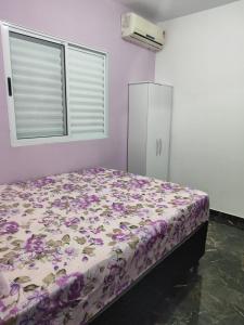 马拉戈日Casa Praia Maragogi - Peroba的一间卧室,床上有紫色鲜花