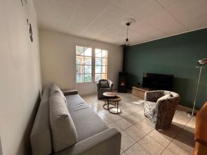 salon z kanapą, krzesłami i telewizorem w obiekcie Maison idéalement située pour les vacances w mieście Notre-Dame-de-Monts