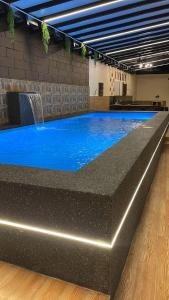 a large swimming pool with a water feature in a building at Villamax Klebang Beach Homestay Melaka 25 Pax 6R4B in Melaka