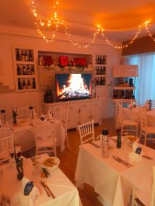 a dining room with white tables and a fireplace at MILANO in Marina di Pietrasanta