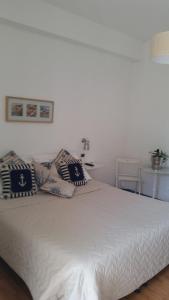 una camera da letto con un letto bianco e cuscini sopra di MILANO a Marina di Pietrasanta