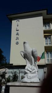 a statue in front of a building with a sign at MILANO in Marina di Pietrasanta