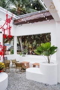 eine Terrasse mit Stühlen, einem Tisch und einer Pflanze in der Unterkunft Lavender Tan Thanh Hotel mini resort in Cong Thanh (3)
