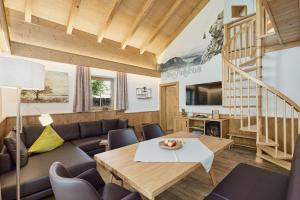 ein Wohnzimmer mit Sofa und Tisch in der Unterkunft Bayern Chalets bei Salzburg und Berchtesgaden mit Whirlpool und Sauna in Ainring