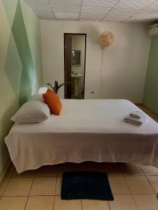 - une chambre avec un grand lit blanc et des oreillers orange dans l'établissement Home 99, à San Mateo