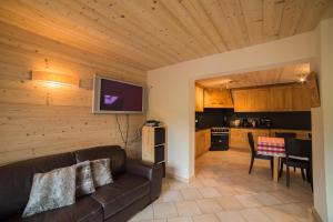 a living room with a couch and a kitchen at Les Azalées 7 in Les Gets