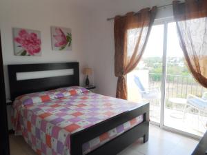een slaapkamer met een bed en een balkon bij Maggy's House in La Romana