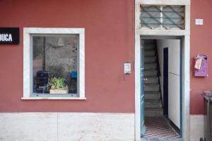 a red building with a window with a potted plant at Casa Terrazzino Bianca in Levanto