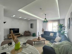 sala de estar con sofá azul y mesa en Saf-Saf Apartment 2 en La Marsa