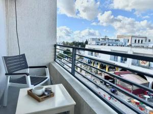 a chair on a balcony with a view of a city at Saf-Saf Apartment 2 in La Marsa