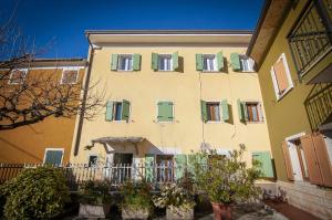 un gran edificio con ventanas verdes y amarillas en Dimora Montelago Apartment Roby, en SantʼAmbrogio di Valpolicella