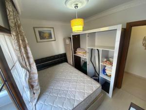 een kleine slaapkamer met een bed en een plank bij Daire in Didim