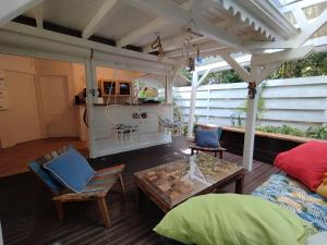 a screened in porch with a table and chairs at Blue Kaz Caraïb in Pointe-Noire