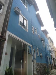 un edificio azul con ventanas en una calle en Flat da Natasha, en Arraial do Cabo