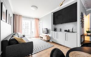 a living room with a couch and a kitchen at Flatbook - City Center Apartments Scala Moderna in Gdańsk
